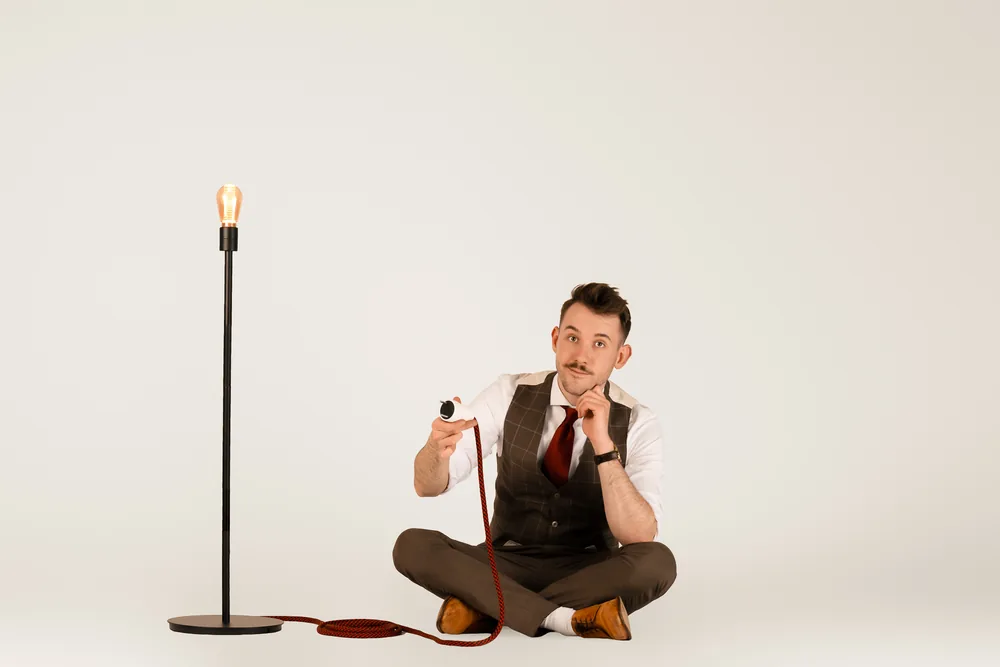 Maxi Muschaweck zwischen Reisekoffern und einer warmen Lampe — Atelierstimmung.
