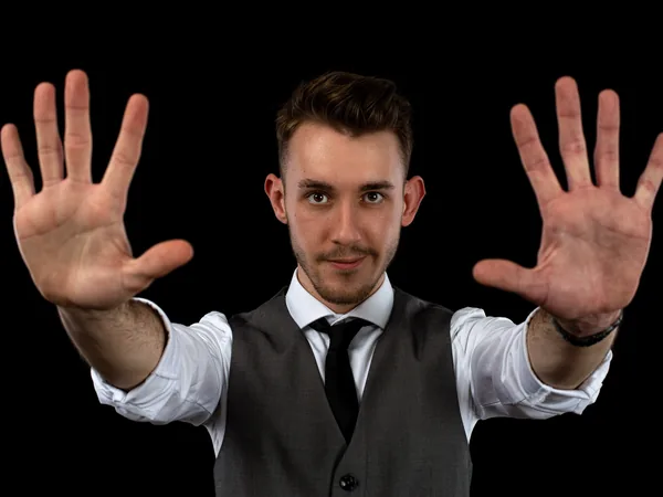 Maxi Muschaweck streckt beide Handflächen in die Kamera, vor schwarzem Hintergrund.
