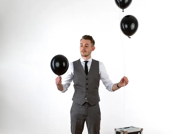Maxi Muschaweck mit schwarzen Luftballons und Flightcase in einem hellen Raum.